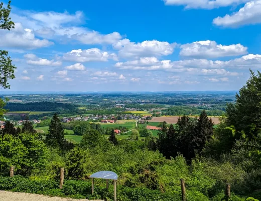Weiter Blick vom Hermannsweg über Felder und Dörfer bei Bielefeld, im Vordergrund eine Panoramatafel